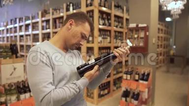有魅力的家伙仔细检查了葡萄酒店里酒瓶标签上的成分。 酒瓶是